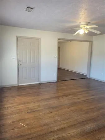 a view of an empty room with wooden floor