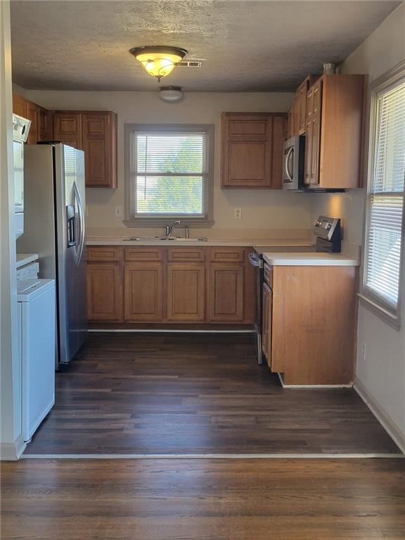 1063 Pleasant Hill Road, Unit A Lawrenceville, GA 30044 - Photo 7 of 18 a kitchen with stainless steel appliances granite countertop a refrigerator a sink dishwasher a stove with wooden floors