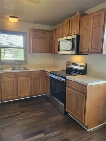 a kitchen with stainless steel appliances a stove a sink and cabinets