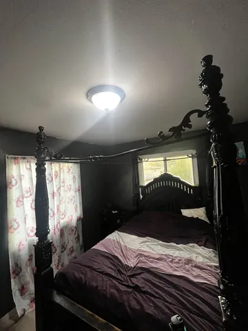 a bedroom with a bed and a chandelier