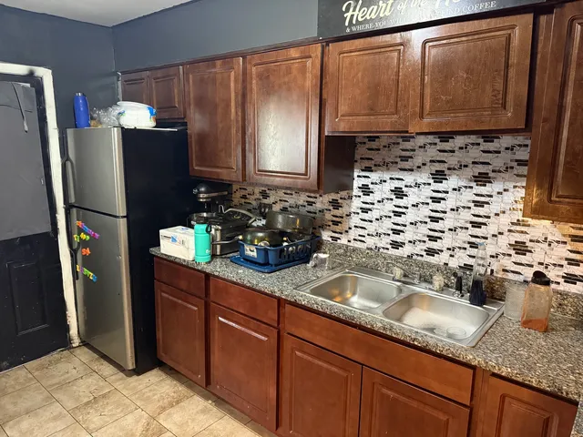 a kitchen with granite countertop stainless steel appliances a refrigerator and a sink