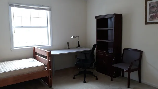 a view of a workspace with furniture and a window