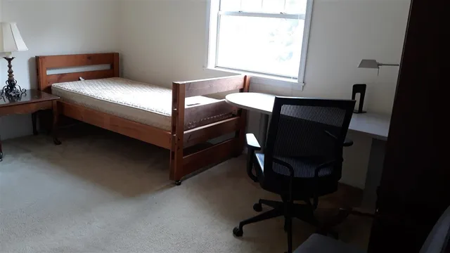 a bed sitting in a bedroom next to a window