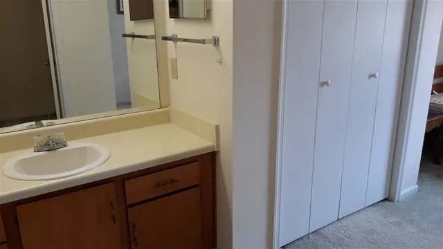 a bathroom with a granite countertop sink and a mirror