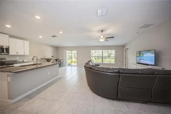 a living room with stainless steel appliances granite countertop furniture and a kitchen