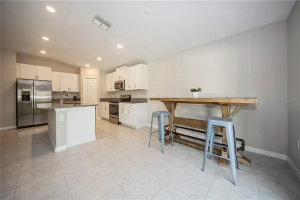 a kitchen with cabinets and chairs