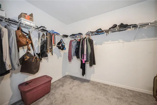 a view of walk in closet with clothes and shoes