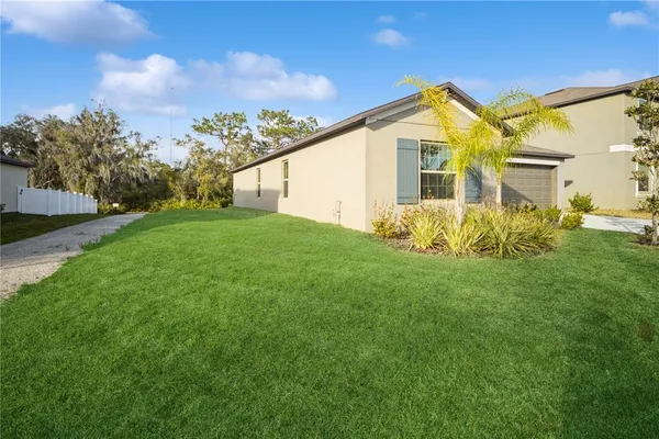 a view of a house with a big yard and potted plants