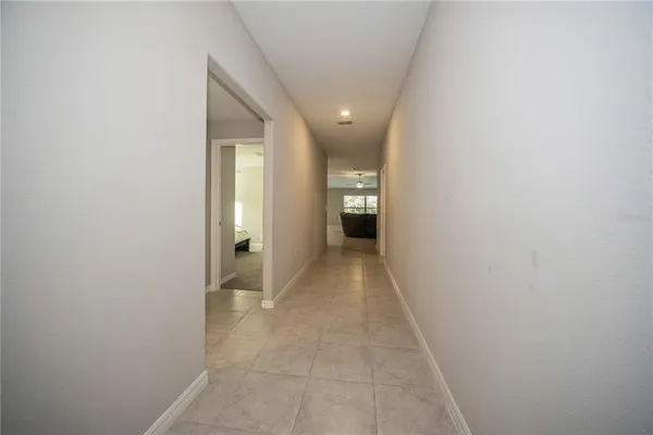 a view of a hallway with wooden floor and a bathroom