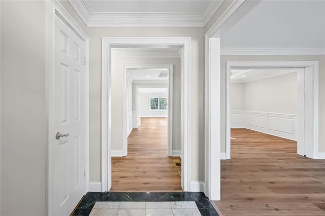 a view of a hallway with wooden floor and closet