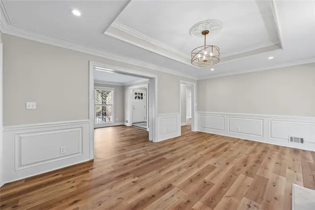 a view of an empty room with wooden floor fireplace and a window