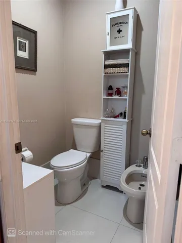 a white toilet sitting next to a bathroom sink
