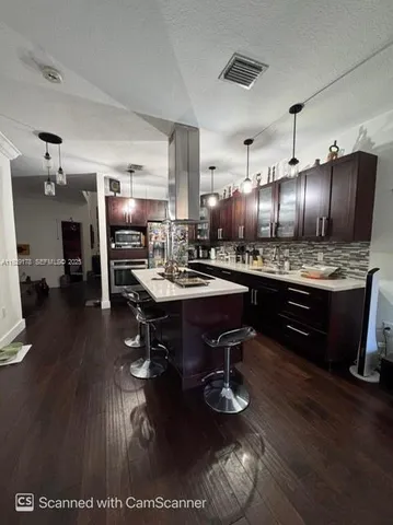 a kitchen with refrigerator and chairs