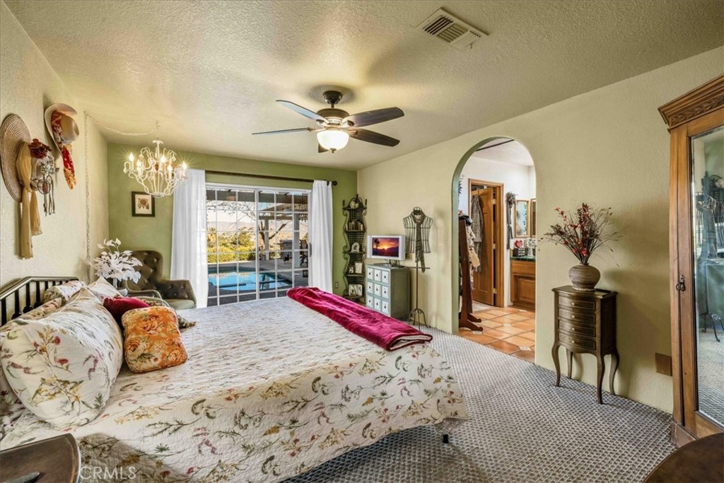 10341 Pinon Avenue Morongo Valley, CA 92256 - Photo 20 of 68 a bedroom with bed and a chandelier