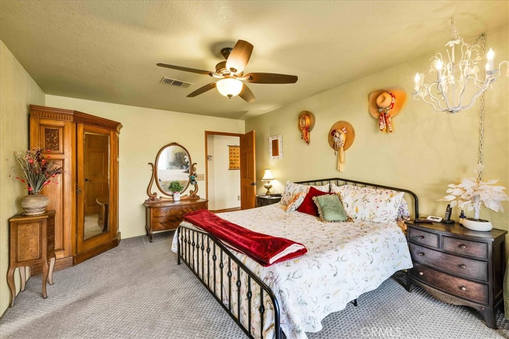 10341 Pinon Avenue Morongo Valley, CA 92256 - Photo 21 of 68 a bedroom with a bed and a chandelier