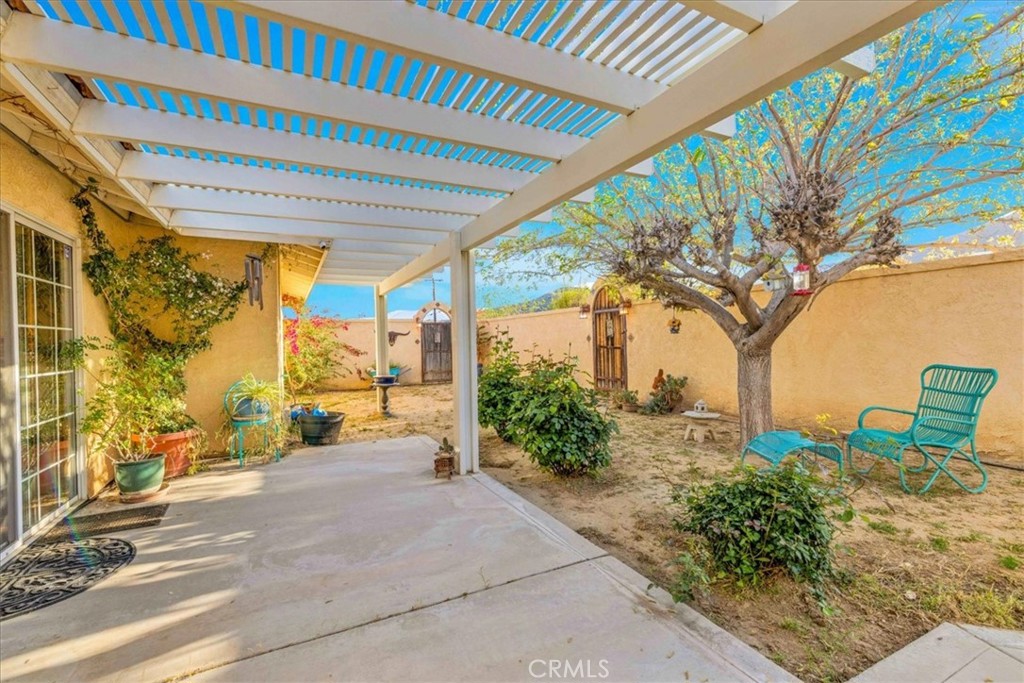 10341 Pinon Avenue Morongo Valley, CA 92256 - Photo 32 of 68 a porch with a table and chairs next to a yard