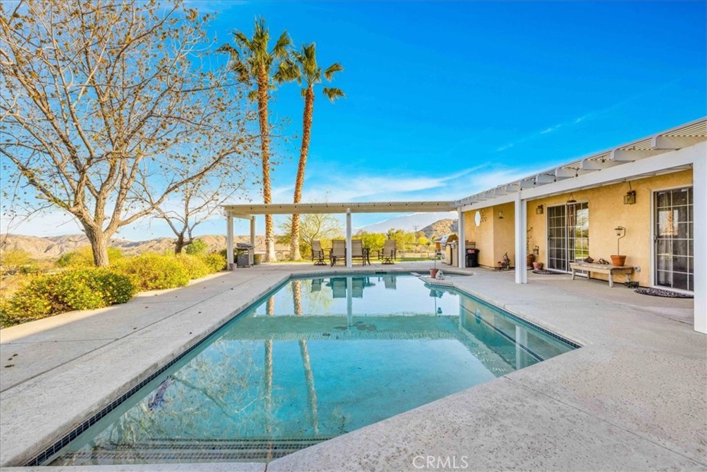 10341 Pinon Avenue Morongo Valley, CA 92256 - Photo 35 of 68 a view of a swimming pool with a patio
