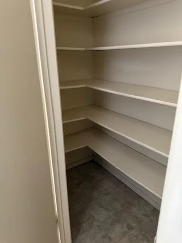 a view of walk in closet with empty racks