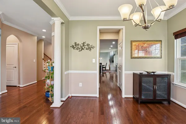 a view of a hallway with wooden floor and a living room