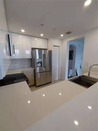 a kitchen with stainless steel appliances a sink and a refrigerator