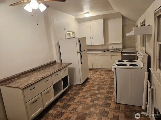a kitchen with white cabinets and white appliances