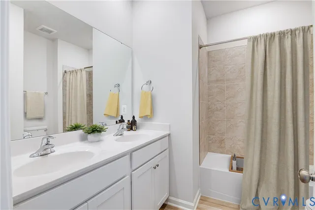 a bathroom with double sink and a mirror