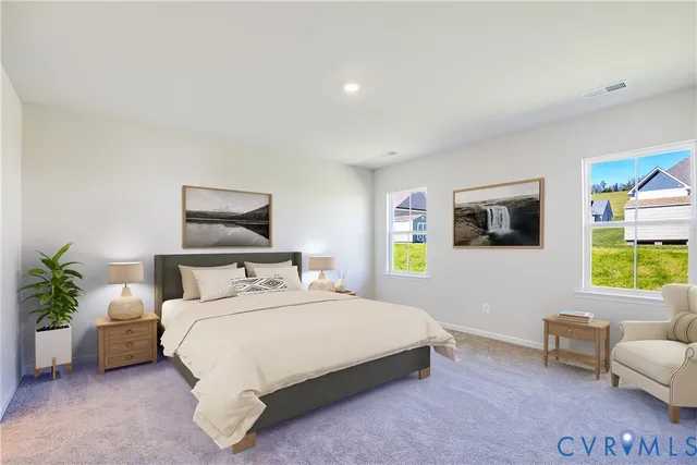 a bedroom with a bed a couch and paintings on the wall