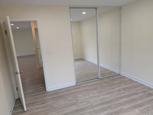 an empty room with wooden floor and entrance