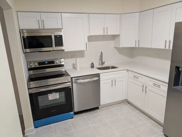 a kitchen with white cabinets and stainless steel appliances