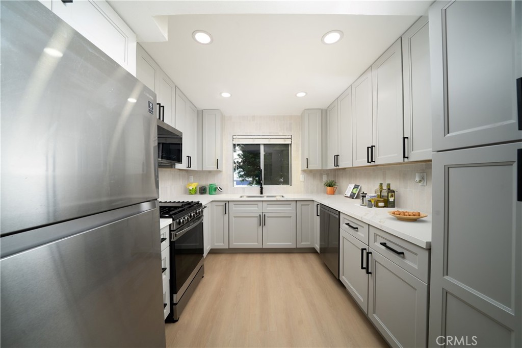 1067 252nd Street, Unit 7 Harbor City, CA 90710 - Photo 1 of 23 a kitchen with white cabinets and appliances