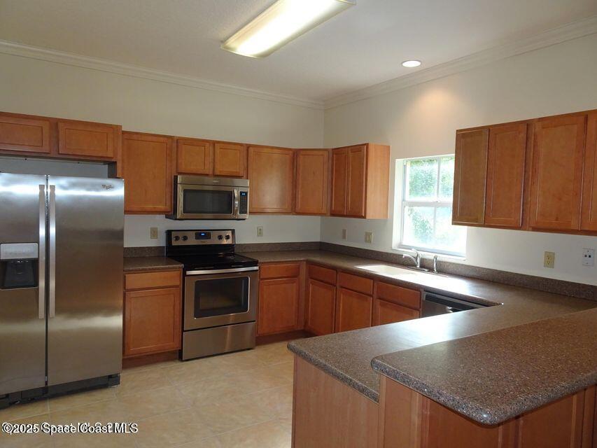 630 Cedar Side Circle Northeast Palm Bay, FL 32905 - Photo 5 of 17 a kitchen with granite countertop stainless steel appliances a sink a stove a microwave a counter top and cabinets