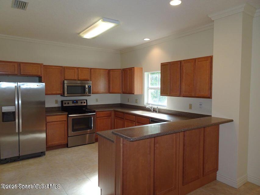 630 Cedar Side Circle Northeast Palm Bay, FL 32905 - Photo 6 of 17 a kitchen with stainless steel appliances granite countertop a sink a stove a refrigerator a microwave a refrigerator and island