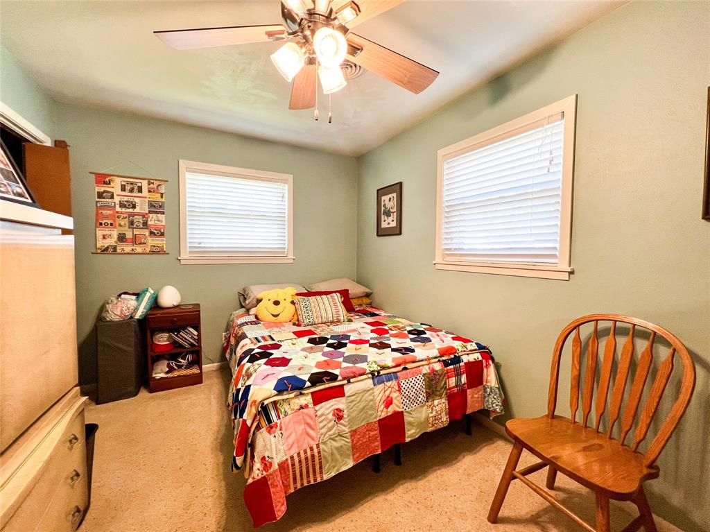 1009 North 7th Street Haskell, TX 79521 - Photo 15 of 26 a bedroom with a bed and a chandelier