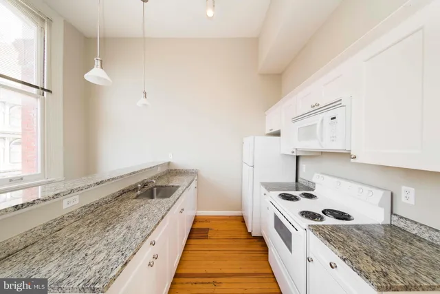 a view of kitchen with wooden floor and electronic appliances