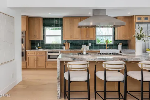 a kitchen with a table chairs sink and cabinets