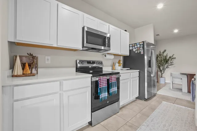 a kitchen with stainless steel appliances granite countertop a refrigerator and a stove top oven