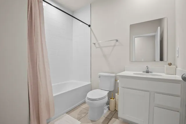 a bathroom with a granite countertop sink toilet a large mirror and shower