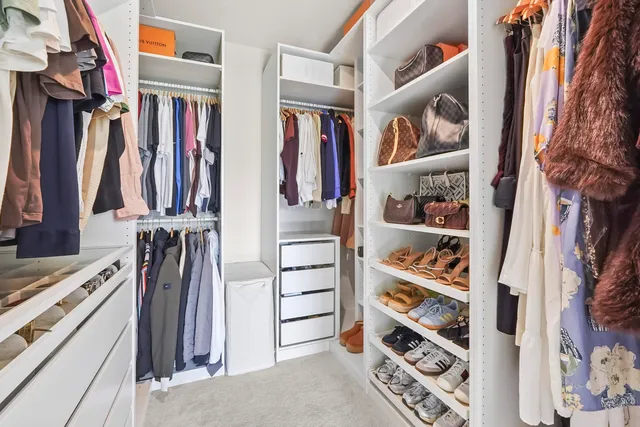 a view of walk in closet with clothes and shoes