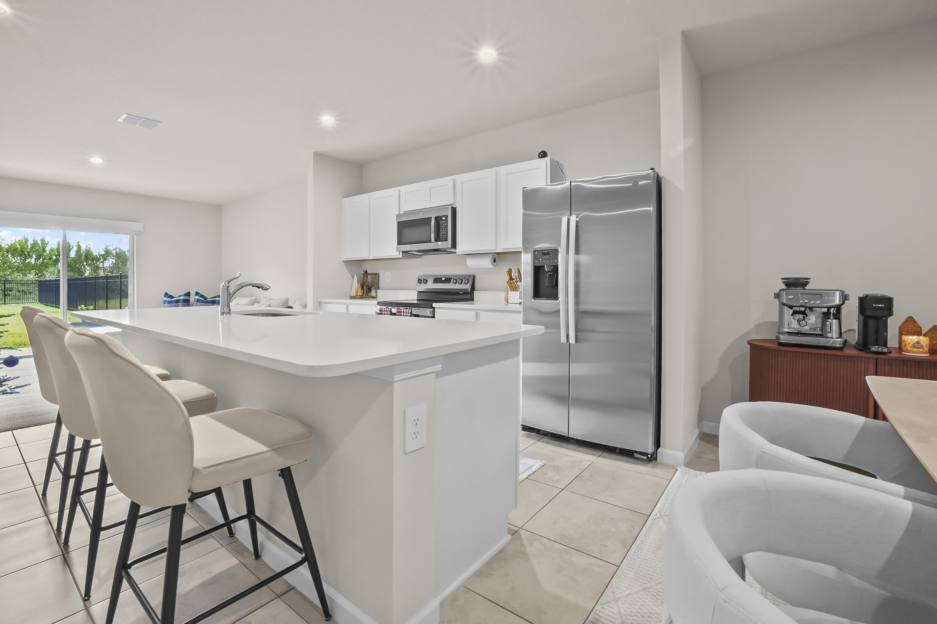 309 Raspberry Road Fort Pierce, FL 34981 - Photo 6 of 38 a kitchen with stainless steel appliances a refrigerator a sink a stove a dining table and chairs with wooden floor