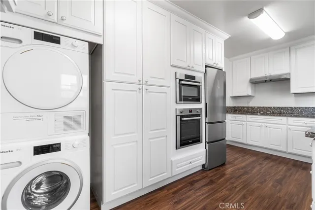 a kitchen with cabinets a washer and dryer