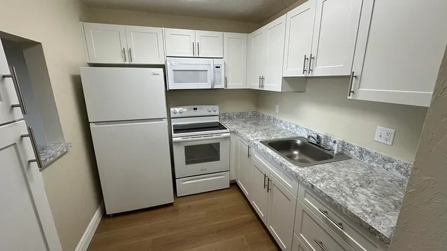 a kitchen with white cabinets and white stainless steel appliances