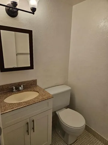 a bathroom with a toilet a sink and mirror