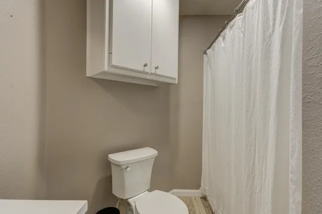 a white toilet sitting next to a white cabinet