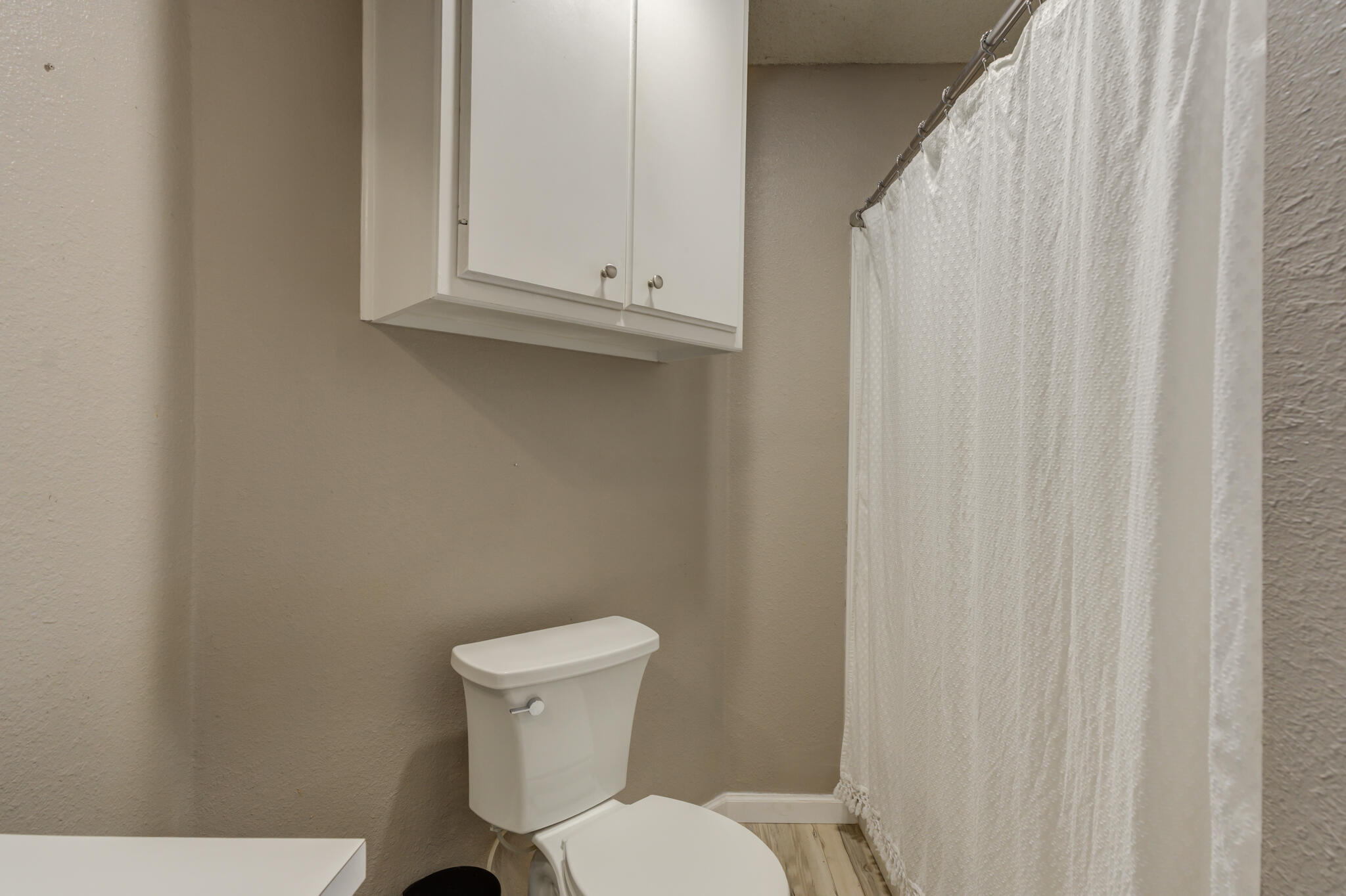 5813 88th Place Lubbock, TX 79424 - Photo 13 of 30 a white toilet sitting next to a white cabinet