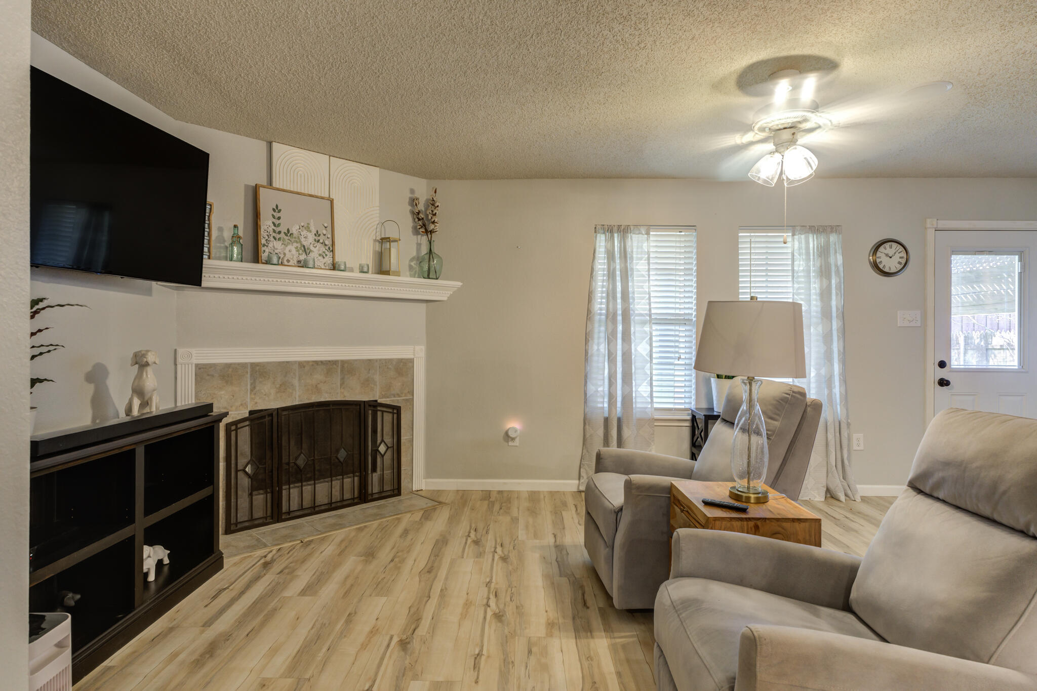 5813 88th Place Lubbock, TX 79424 - Photo 17 of 30 a living room with furniture a flat screen tv and a fireplace
