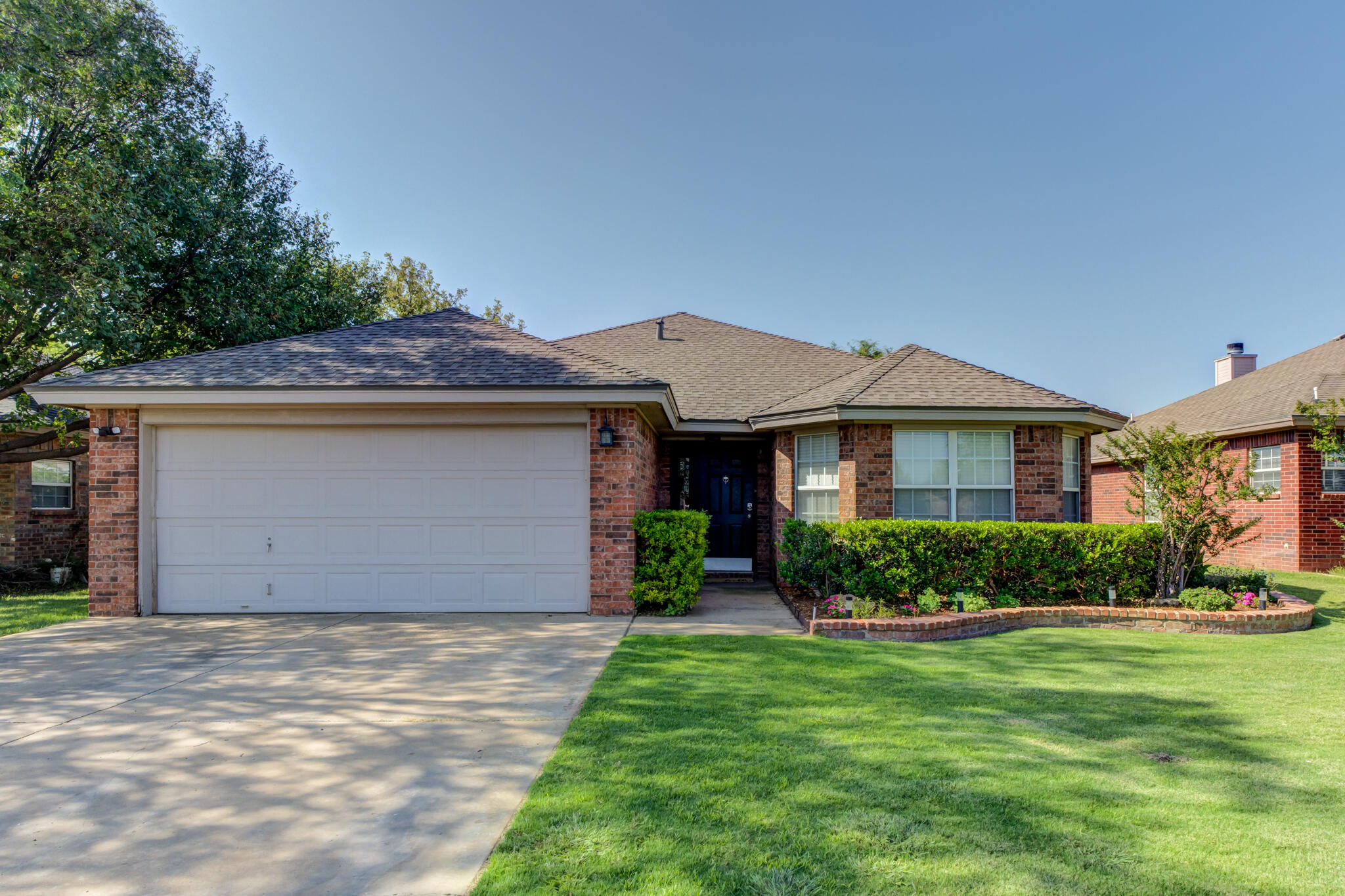 5813 88th Place Lubbock, TX 79424 - Photo 2 of 30 a front view of a house with a yard and garage