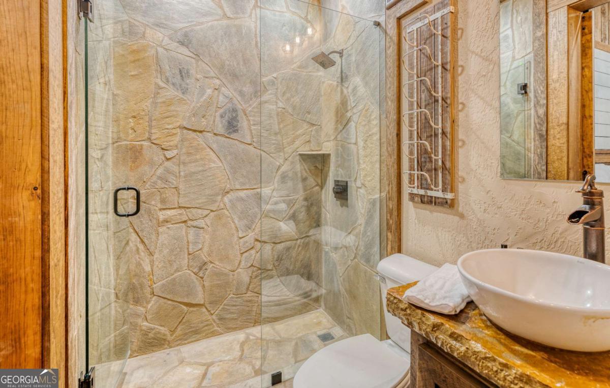 280 Pointe Of View, Unit 15 Blue Ridge, GA 30513 - Photo 57 of 72 a bathroom with a granite countertop toilet and a shower