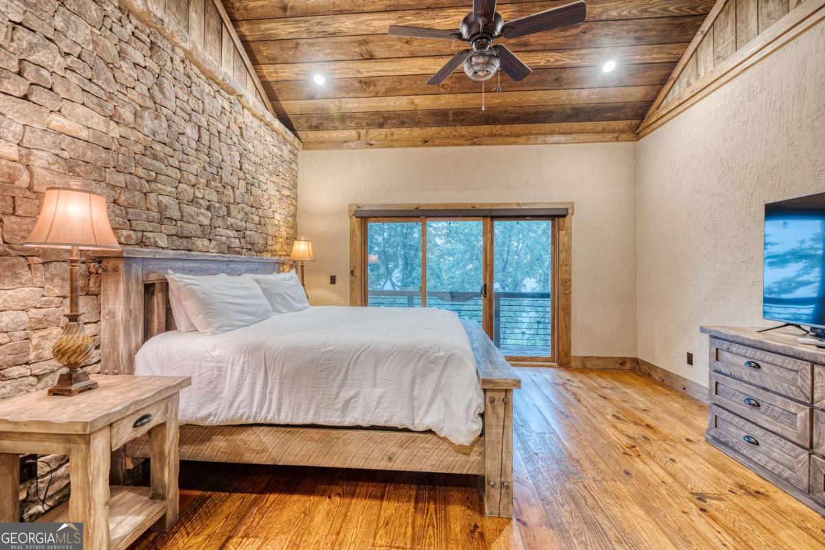 280 Pointe Of View, Unit 15 Blue Ridge, GA 30513 - Photo 69 of 72 a bedroom with a large bed and a chandelier