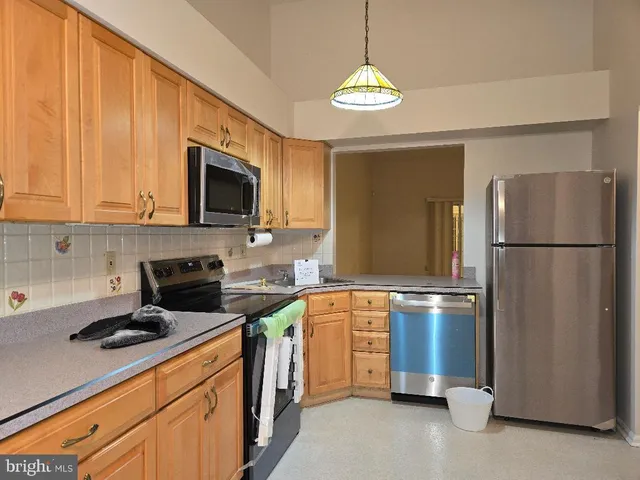 a kitchen with stainless steel appliances granite countertop a refrigerator a stove a sink and a microwave