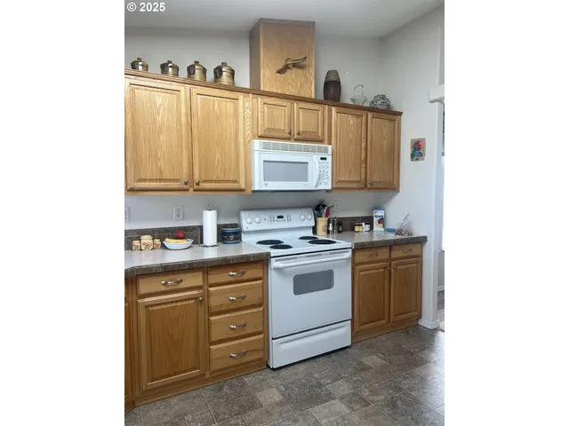 a kitchen with cabinets appliances and a window